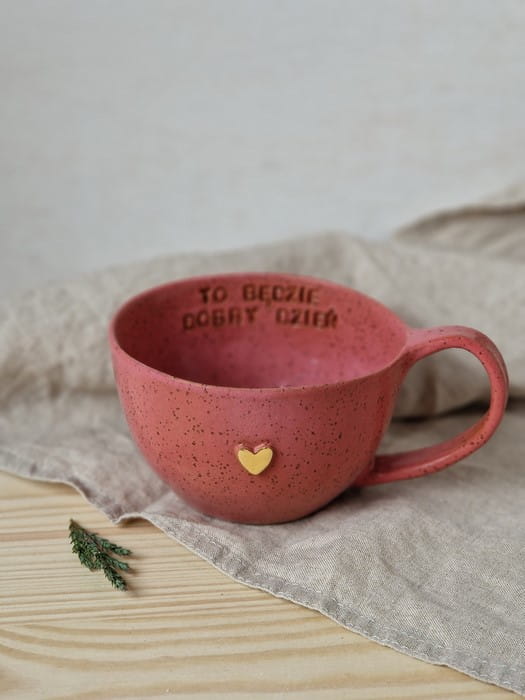 Malinowa filiżanka ceramiczna 300 ml handmade ustawiona na stole