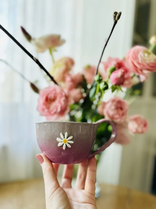 Filiżanka ceramiczna z kwiatem 300 ml szaro-różowa trzymana w dłoni handmade