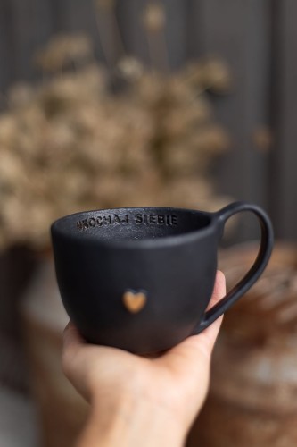 Czarny kubek ceramiczny 400 ml handmade, trzymany w dłoni