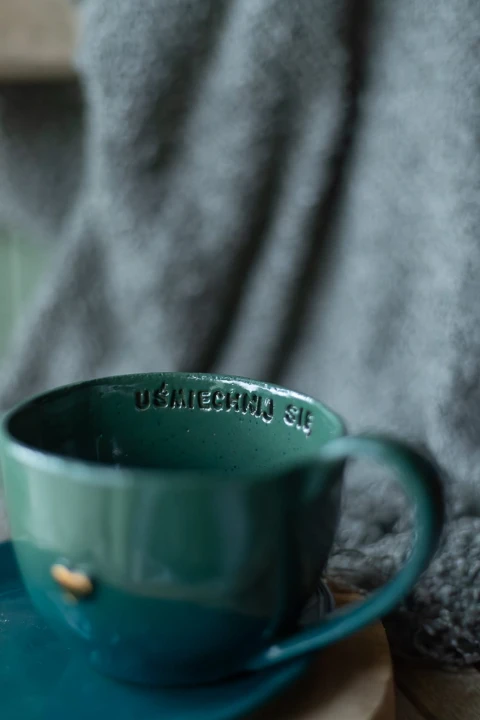 Zbliżenie na dekoracyjny napis na zielono-morskim kubku ceramicznym 400 ml handmade