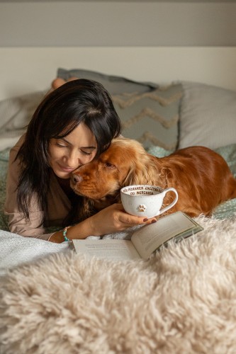 Filiżanka 300 ml ze złotą łapką i afirmacją trzymana w dłoni, kobieta przytula psa