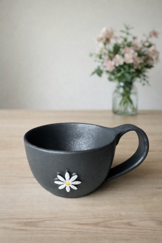 Czarna filiżanka z kwiatem